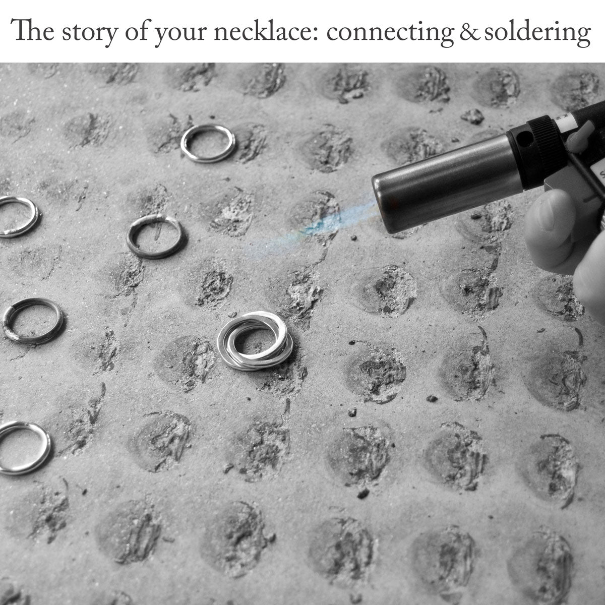 Close-up of an asbestos mat showing a jewellery-making process involving three flattened rings being joined together using silver solder and a blow-torch, under the caption 'The story of your necklace: connecting and soldering'