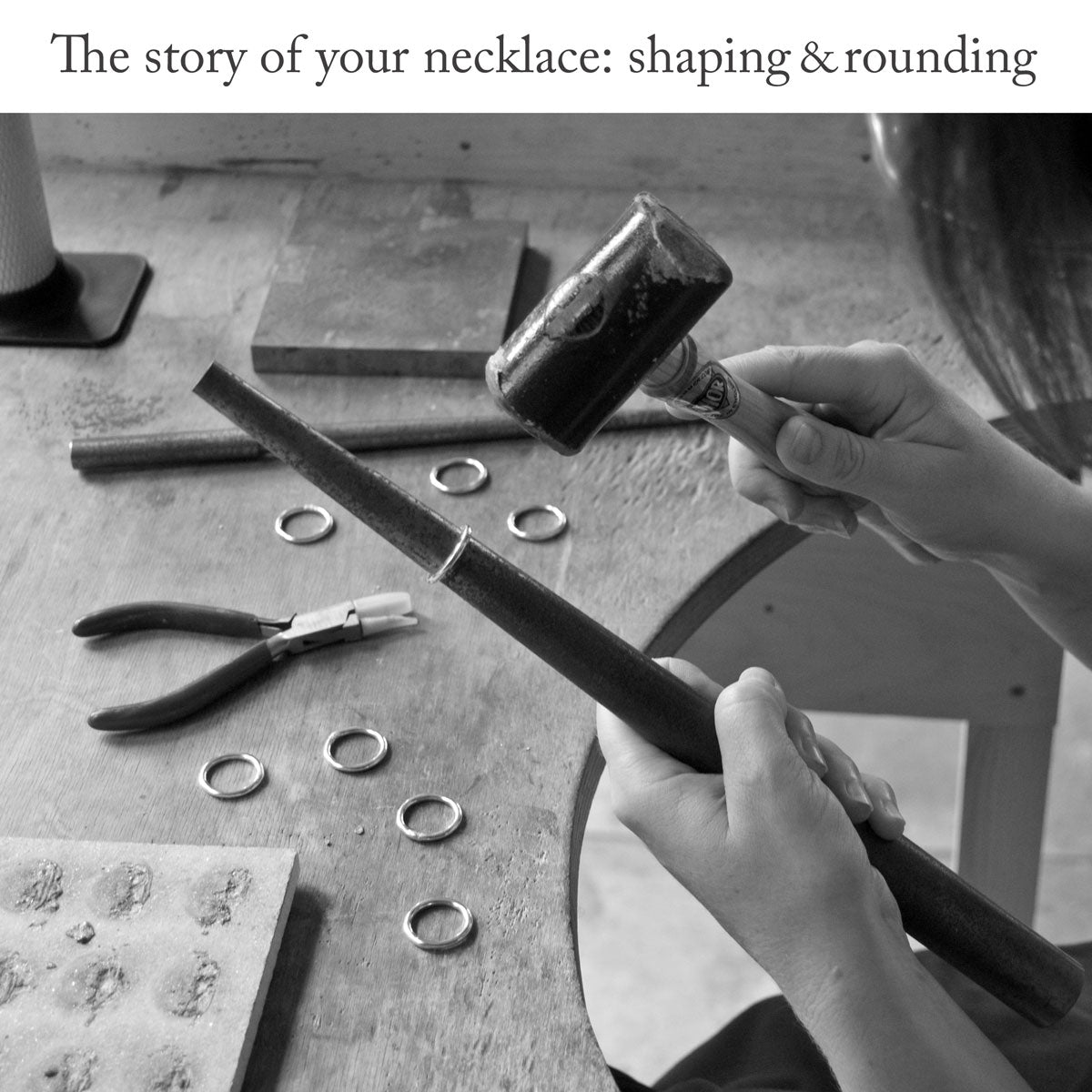Close-up of silversmith sitting at a workbench using a mandrel and rawhide mallet to shape and round a thick piece of sterling silver wire with the headline text &#39;The story of your necklace: shaping and rounding&#39;