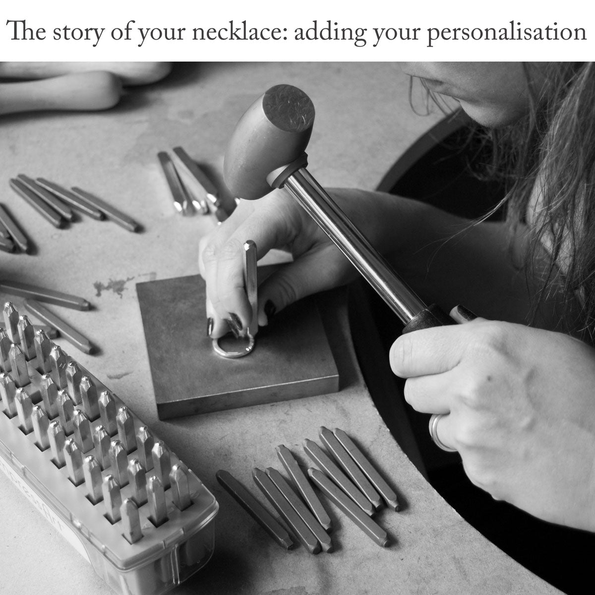 Close-up of women sitting at a jewellery bench using a metal-stamping block, brass hammer and a selection of metal stamps to apply letters to a sterling silver ring under the caption 'The story of your necklace: adding your personalisation'
