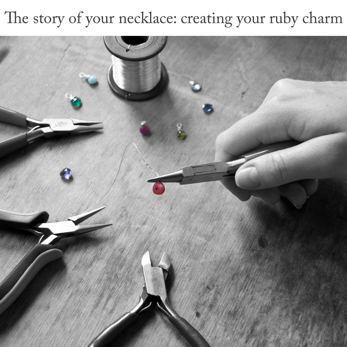 Handcrafting a ruby charm with jewellery-making tools and wire on the wooden surface of a work bench